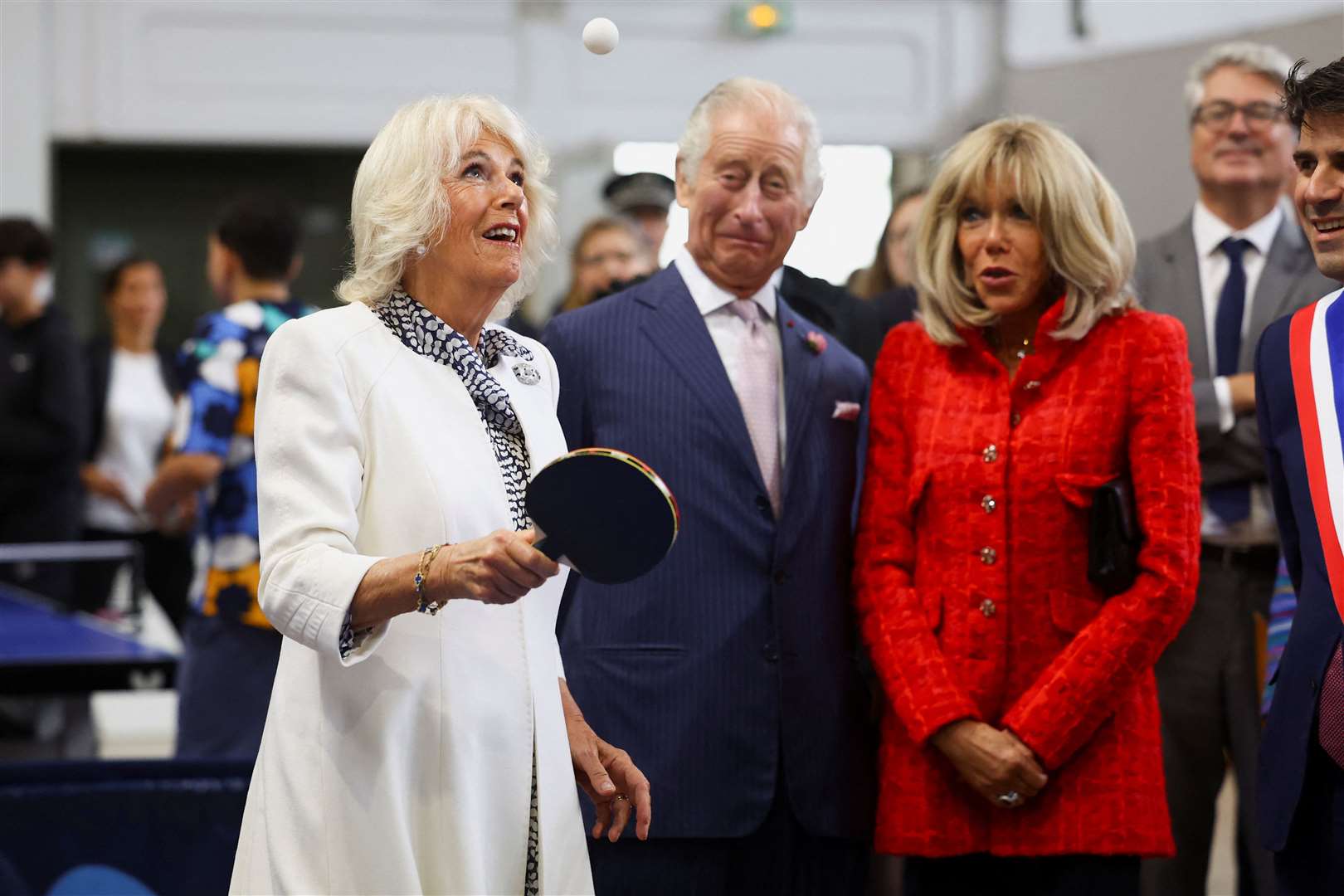 Queen Camilla plays table tennis next to the King and France’s First Lady Brigitte Macron at a sports centre in Saint-Denis, Paris (Hannah McKay/PA)