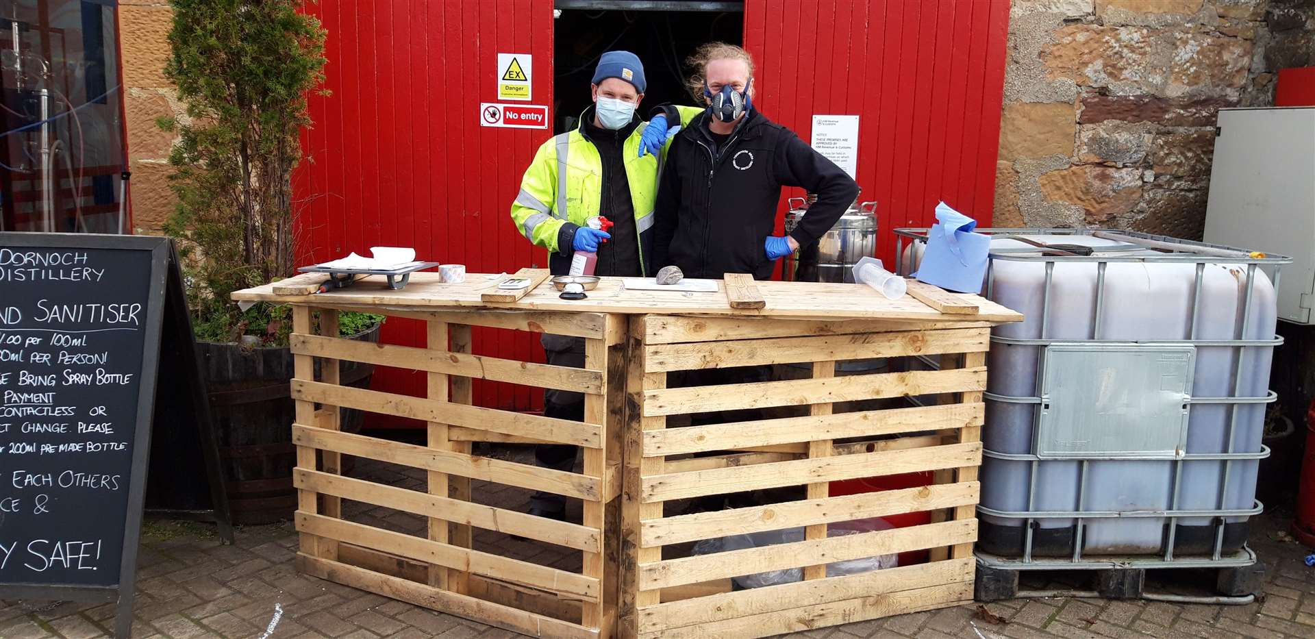 Simon Thompson (right) and brother Philip, operators of Dornoch Distillery, sell hand sanitiser from an outdoor stall.