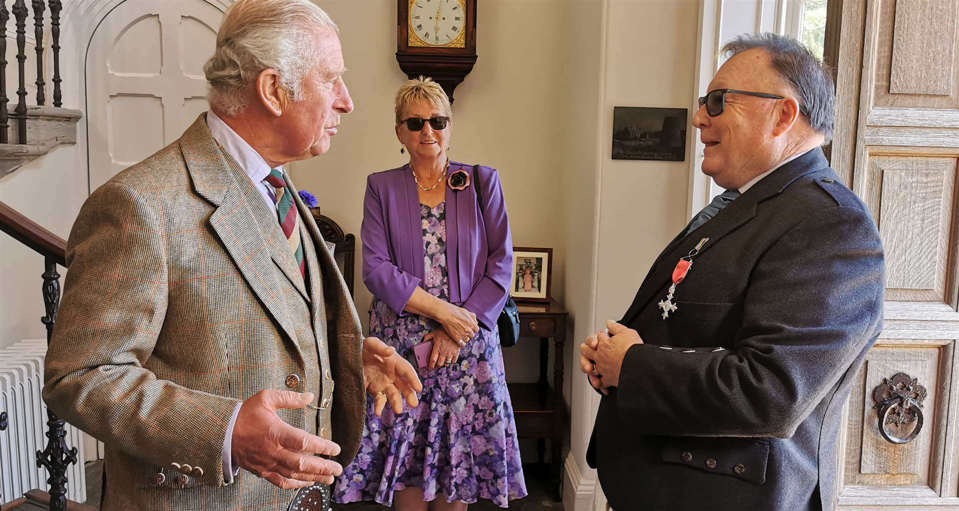 Prince Charles, the Duke of Rothesay, presenting David Flear with his MBE in the foyer of the Castle of Mey, with Mr Flear's wife Helen looking on.