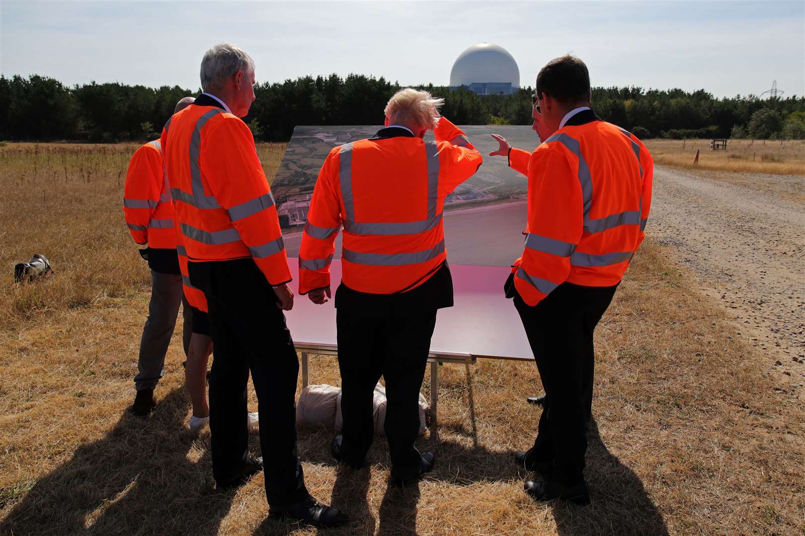 Mr Johnson (centre) looks at plans for the Sizewell C nuclear power station project (Chris Radburn/PA)