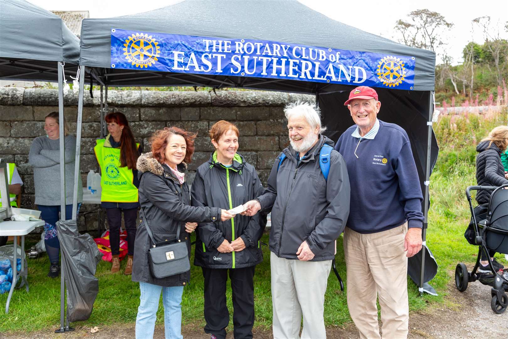 Rotary club president Michelle Johnstone (far left) presents the duck race runners-up with their £100 cash prize. Rotarian Alistair Risk stands far right.