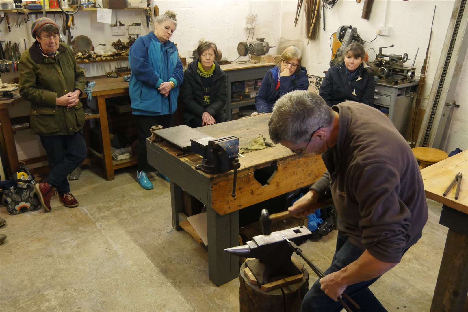 From left: Anne Coombs, Karen Clarke, Barbara Morrison, Kerry MacKay and Adele Gallagher watching closely as Peter begins to ‘grow’ the spoon from the ingot. Picture: Peter Wild