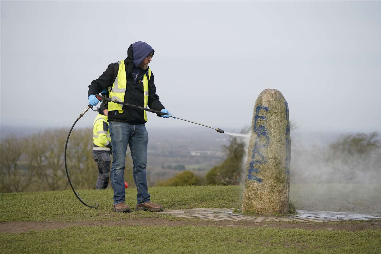 An Office of Public Works worker began the clean-up of graffiti on the Lia Fail standing stone on the Hill of Tara in County Meath after it was vandalised in February (Niall Carson/PA)