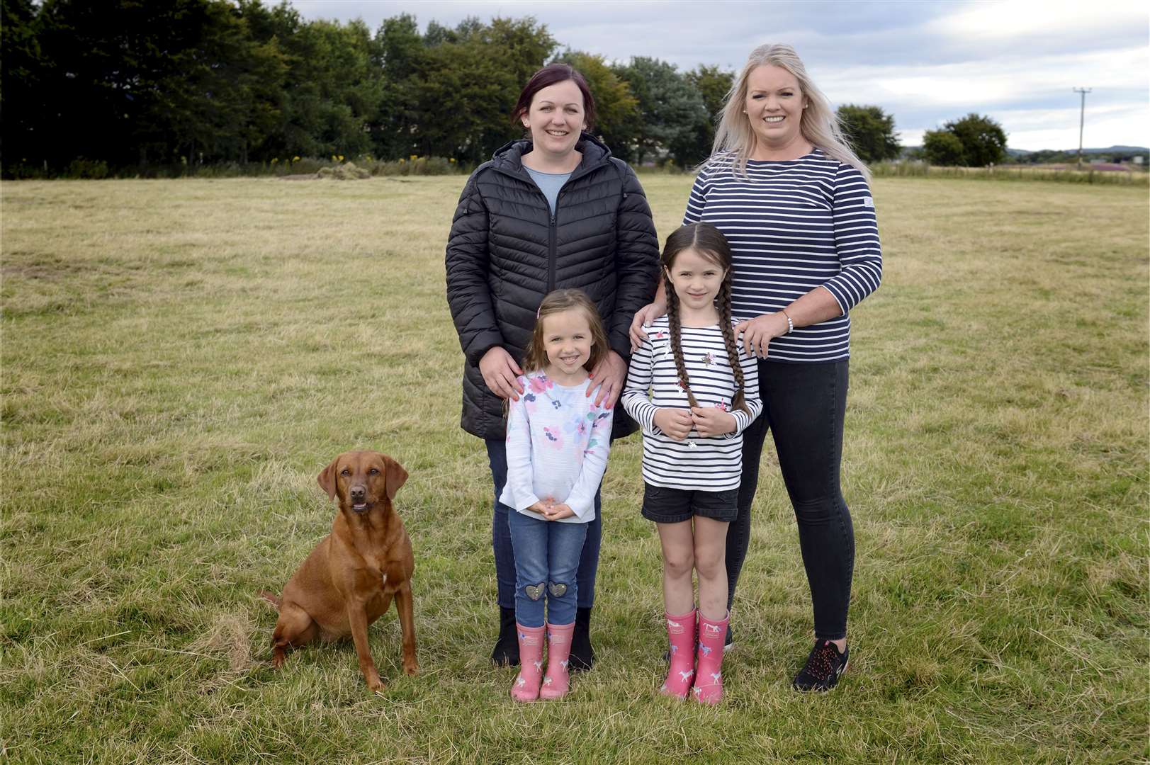 Jennie Wilson, Katie Christie, Aimee Grant (4), Lucy Christie (6) and Skye the labrador on the land that is set to be used for the family business. Picture: James Mackenzie