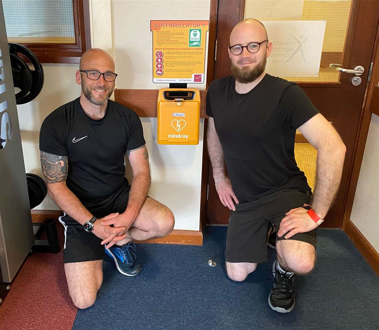 Kinlochbervie gym goers Local Ambulance Technician Sam Barnes on the left and Felix Grosvenor pictured with the new defibrillator.