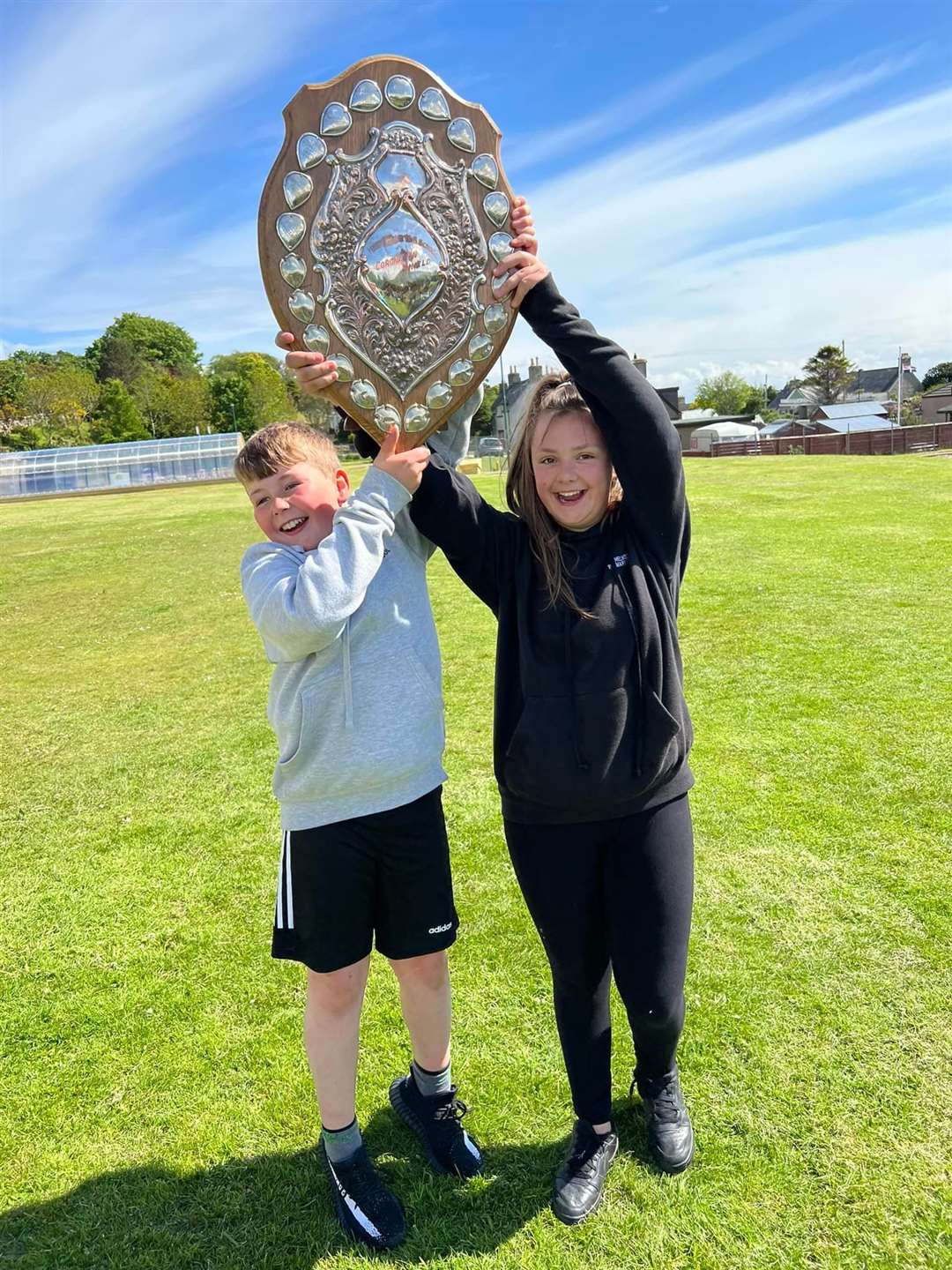 A triumphant Ben Mackenzie and Zoe Sutherland, 2022 captains of Castle, hold aloft the winning team trophy.
