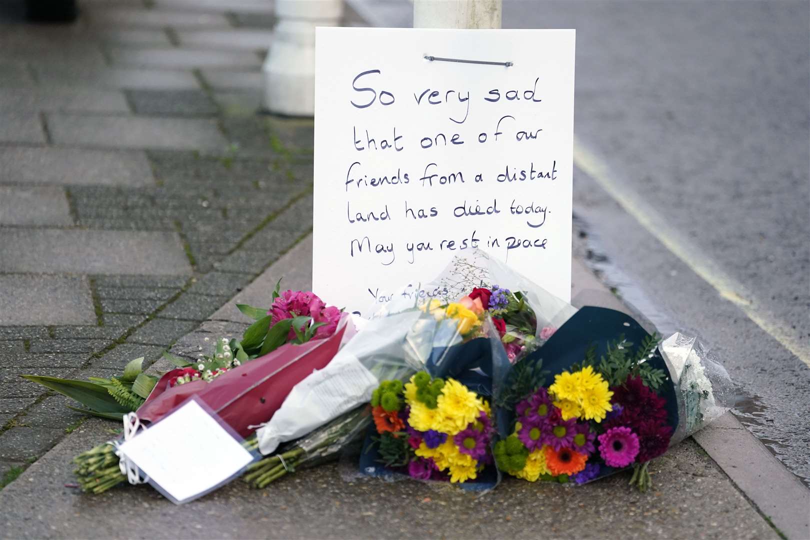 Flowers are left at the entrance at Portland Port in Dorset, following the death of an asylum seeker on board the Bibby Stockholm accommodation barge (Andrew Matthews/PA)