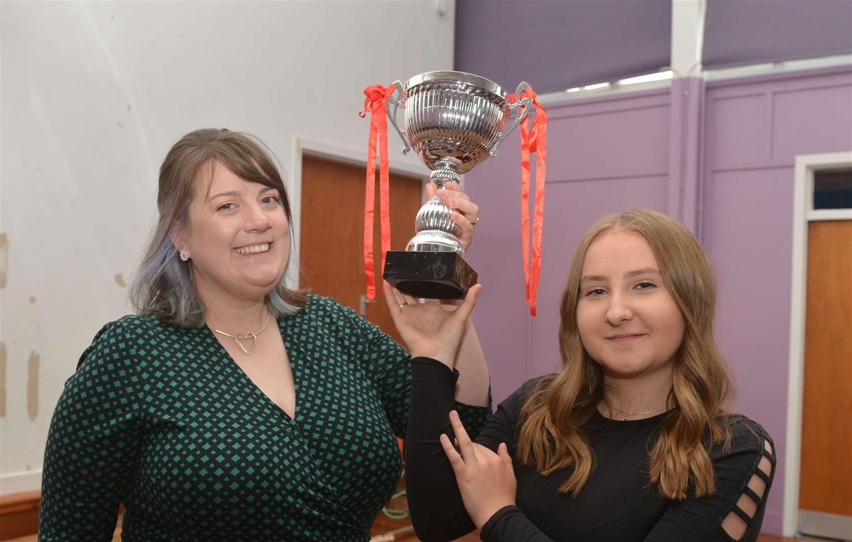 Neve Murray picks up the House Trophy from history and modern studies teacher Emma Sinclair on behalf of her team - Loyal. Picture: Jim A Johnston