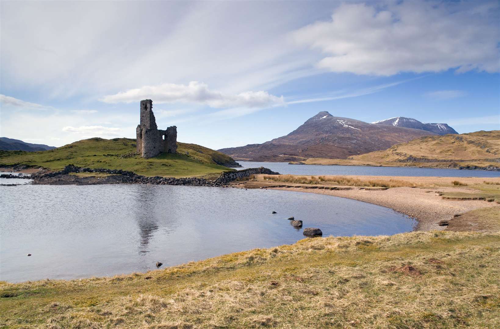 The ruined Arvreck Castle, which stands on a rock promontory in Loch Assynt, is one of the area’s tourist hot spots. Stock Image
