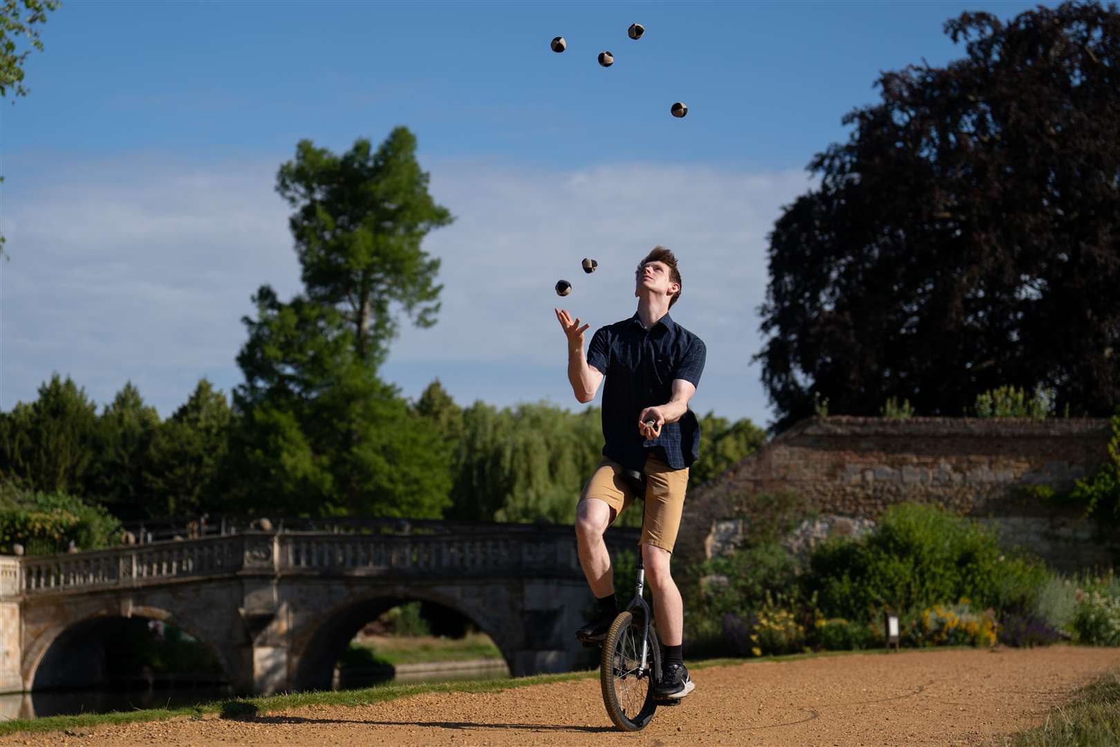 Cambridge University PhD student James Cozens juggling seven balls whilst unicycling around King’s College in Cambridge, having honed his skills with performance analysis software that he developed himself (Joe Giddens/PA)
