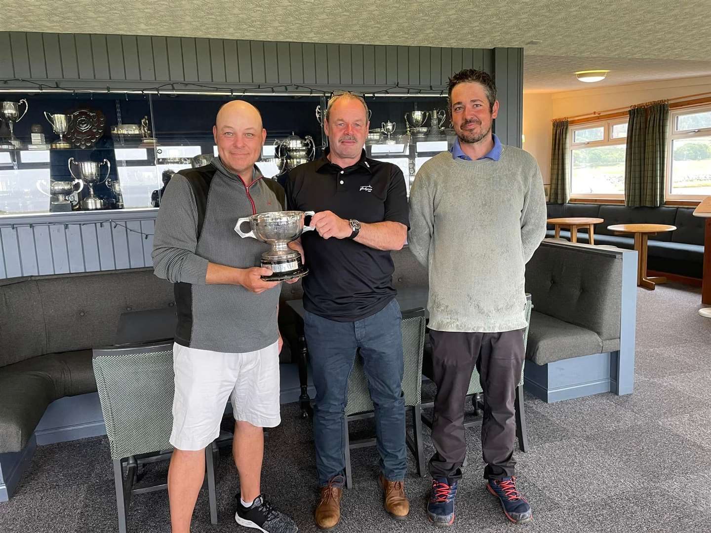 Bryan Urquhart receives the men's trophy from William MacBeath with Neil Edwards runners-up.