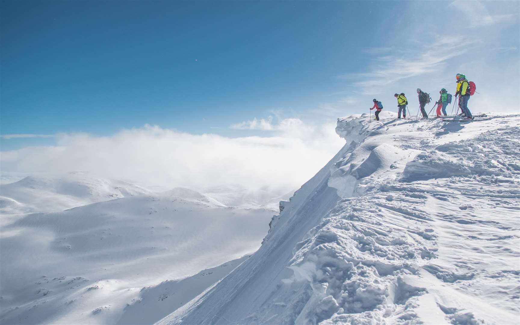 A group of skiers standing above the entrance to the Back Corries at Nevis Range.