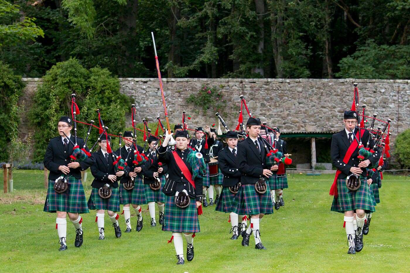 A pipe band performs in the gardens of Dunrobin Castle.