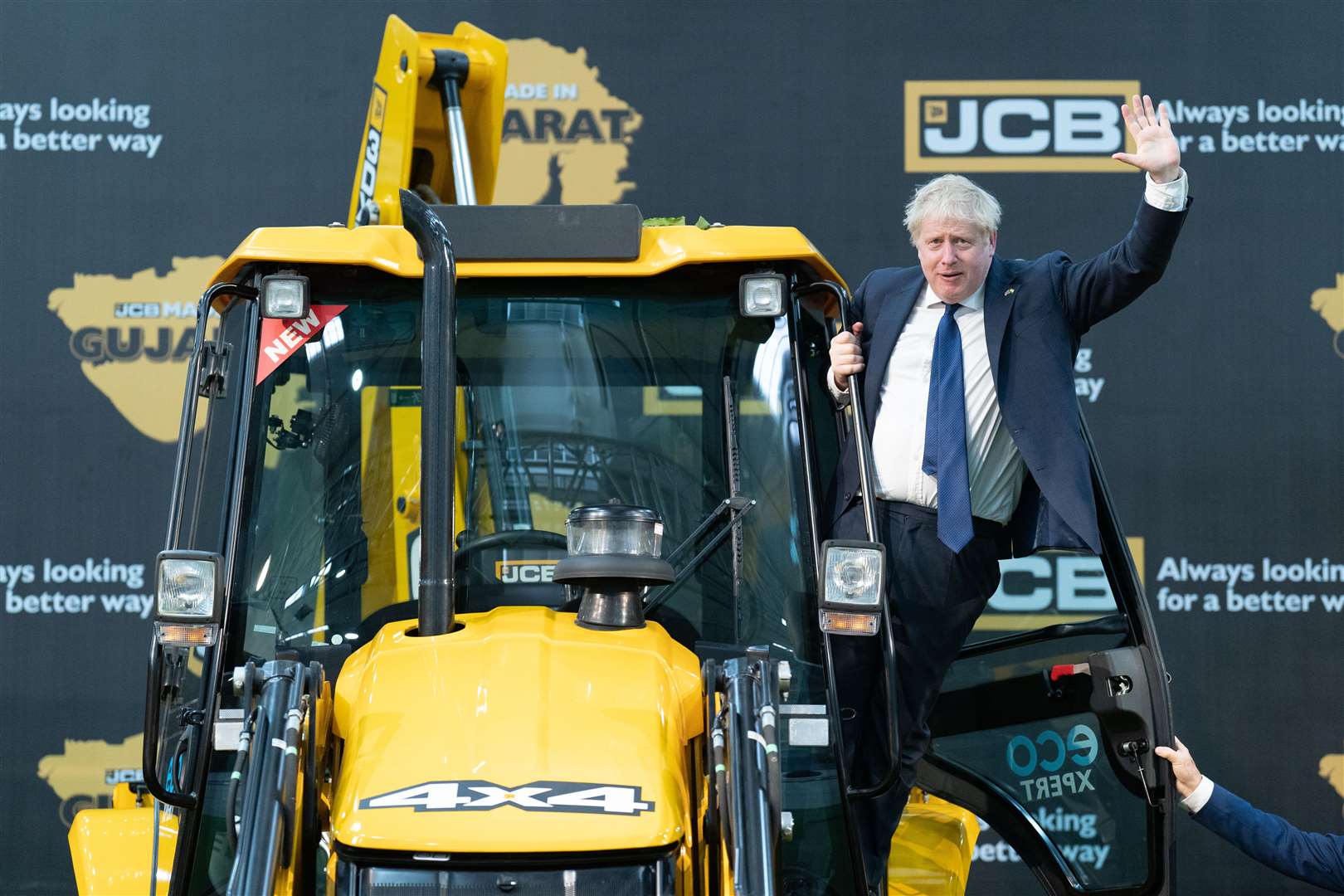 Prime Minister Boris Johnson climbs over a JCB at the new factory in Vadodara, Gujarat (Stefan Rousseau/PA)