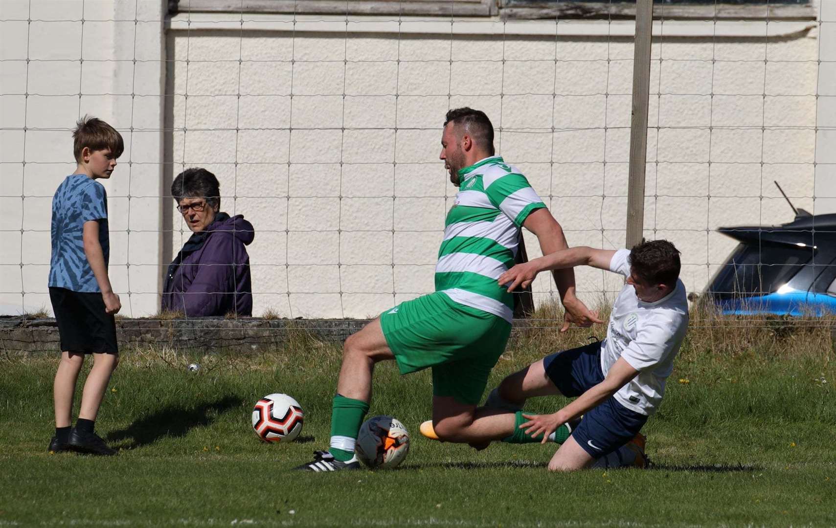 Jake Pirie (Lochinver) challenges Duncan Davidson (Helmsdale United). Photo: David Haines