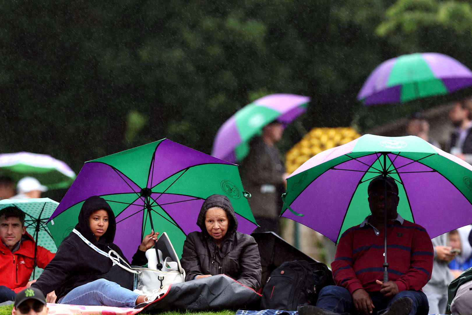 Spectators on the Hill shelter from the rain (Steven Paston/PA)
