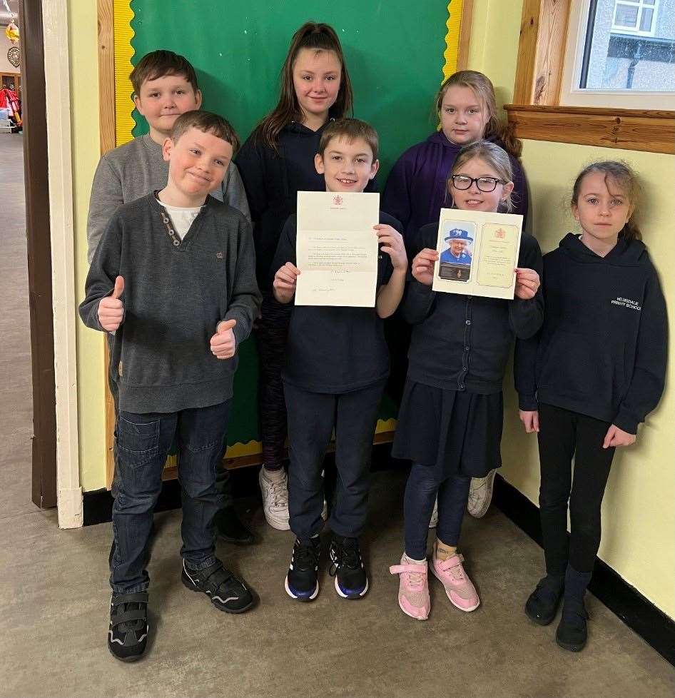 Helmsdale pupils with the letter and card from the Queen. Back row, from left, Riley Roberts, Zoe Sutherland and Roxi Whitehead. Front, from left, Alexander Jappy, Rian Grant, Lorna Hope and Lexi Tricker.