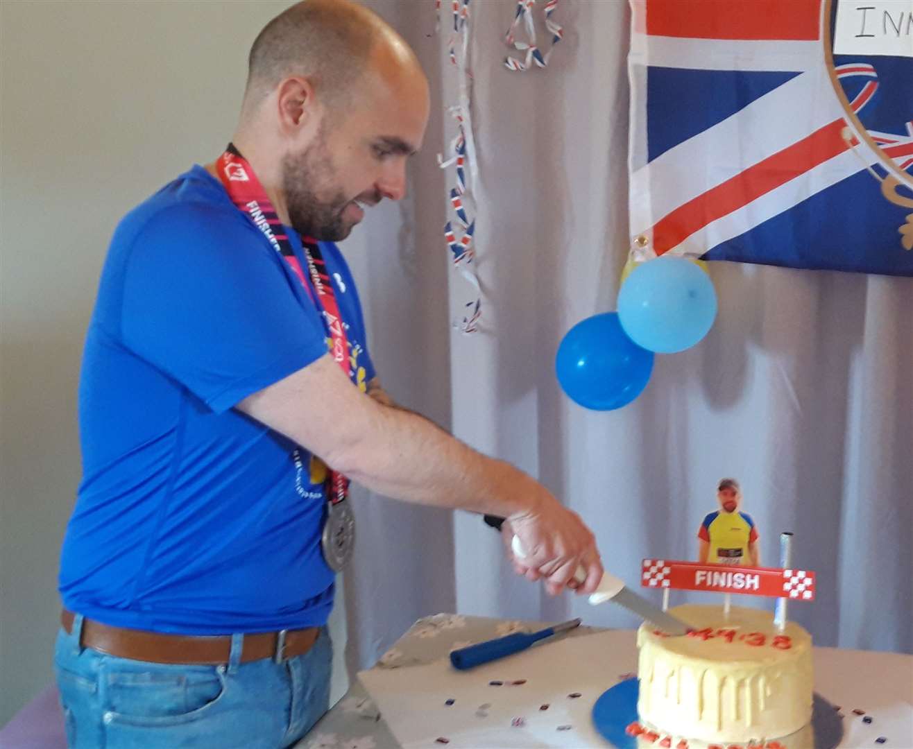 Mr Mackay cuts the cake which was made by Lyla Murray of Single Malt Baking and had a finish line on top of it.