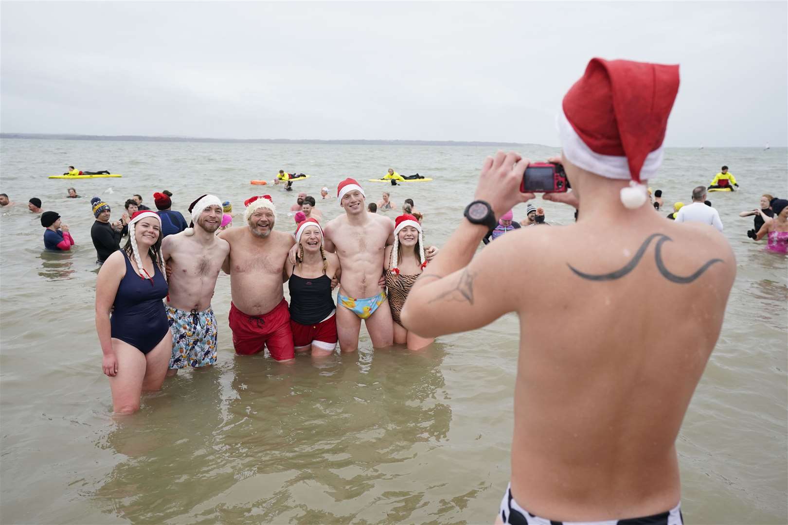 Swimmers pose for a photo during the Gosport New Year’s Day Dip in The Solent at Stokes Bay, Hampshire (Andrew Matthews/PA)