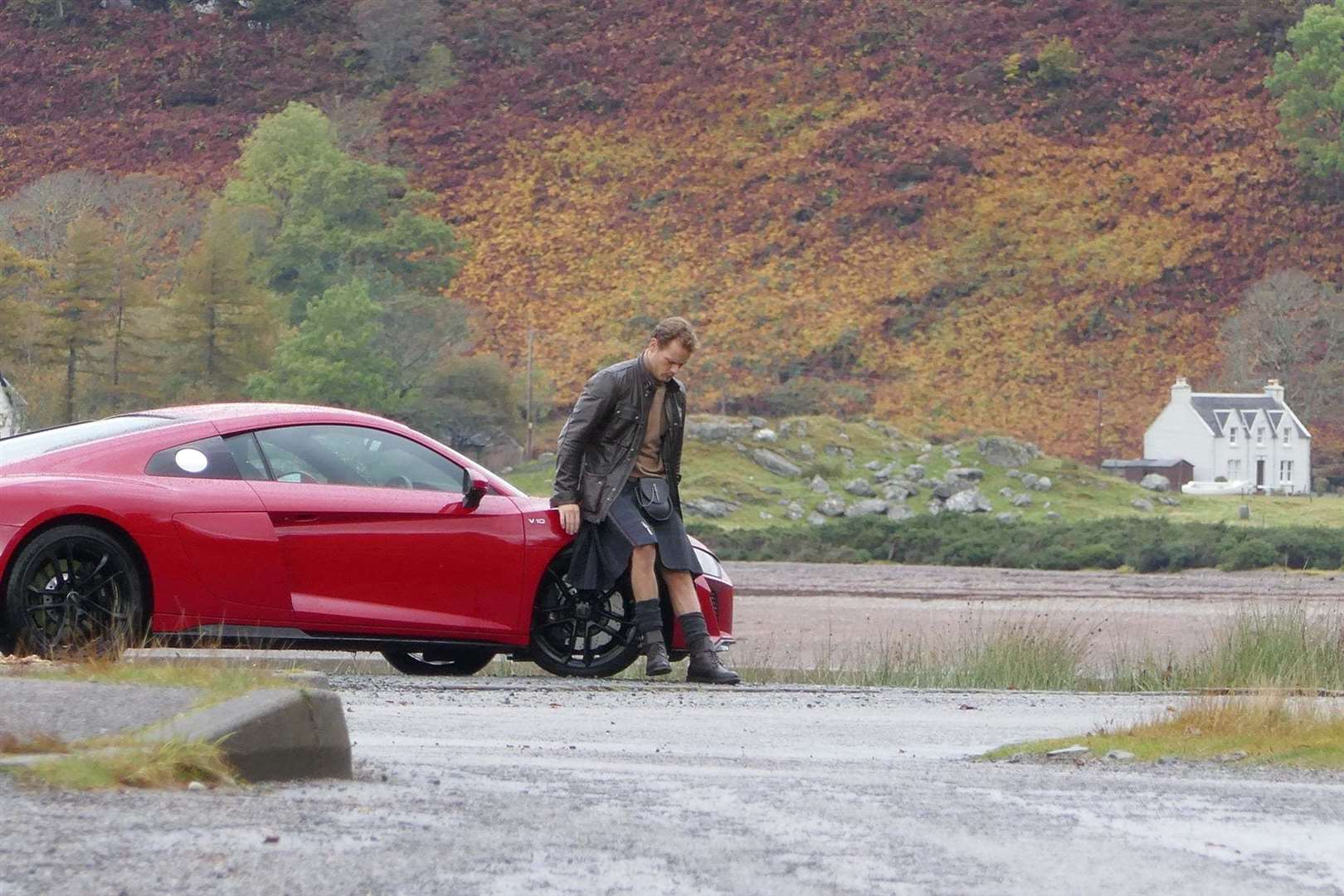 Mr Heughan took time to relax on the bonnet of his car.