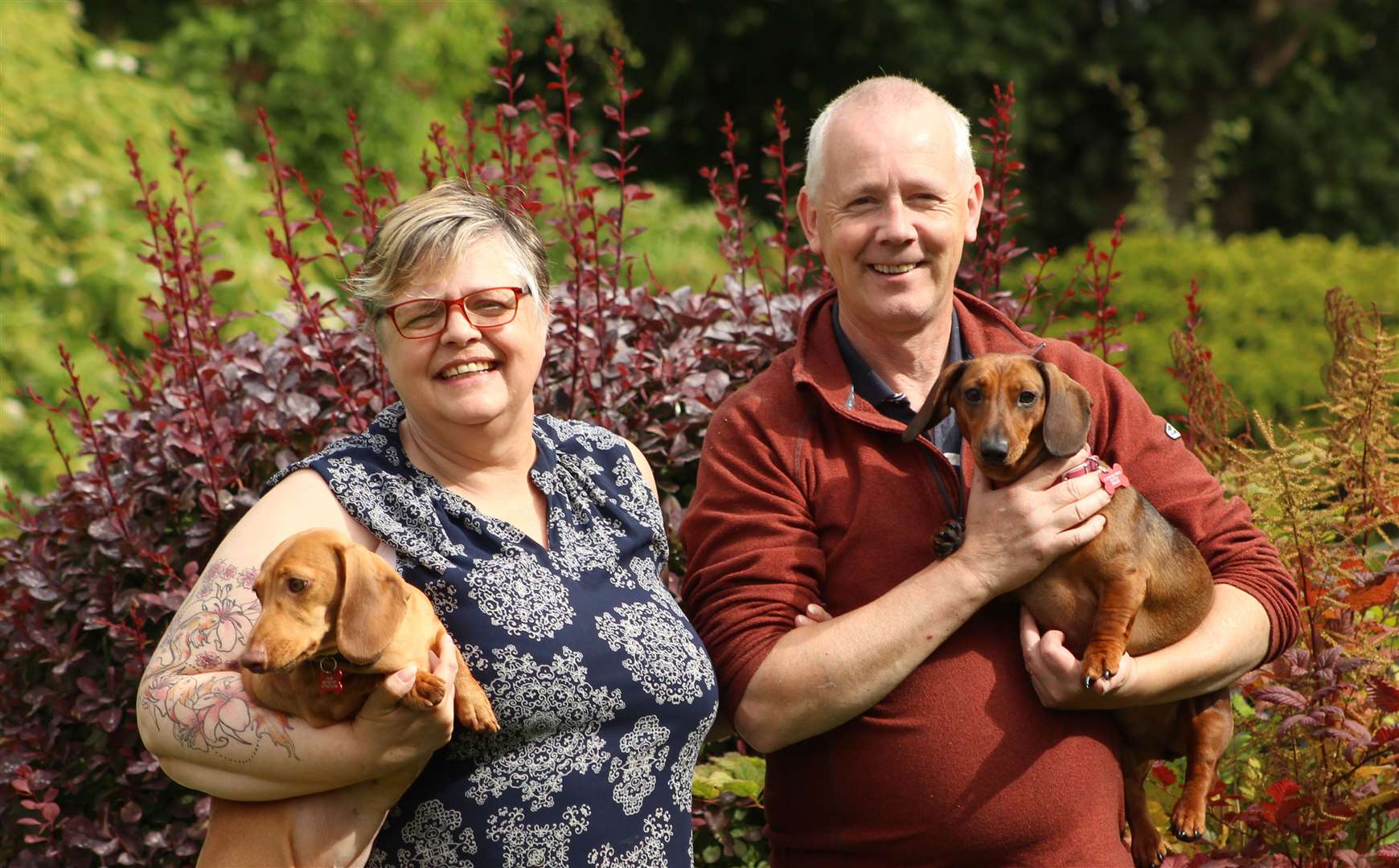 Helen and Alan McCarthy in their garden with dachshunds Fern and Rowan. Picture: Alan Hendry