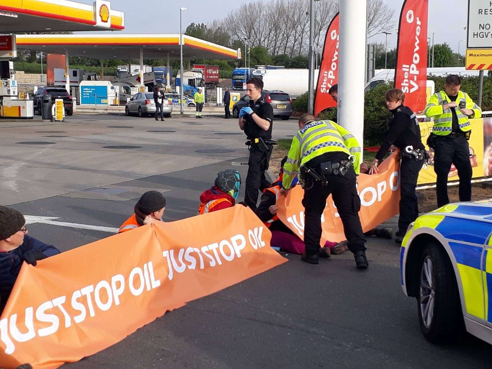 Campaigners staging a protest in the Shell petrol garage at Cobham Services on the M25 in Surrey (Just Stop Oil/PA)