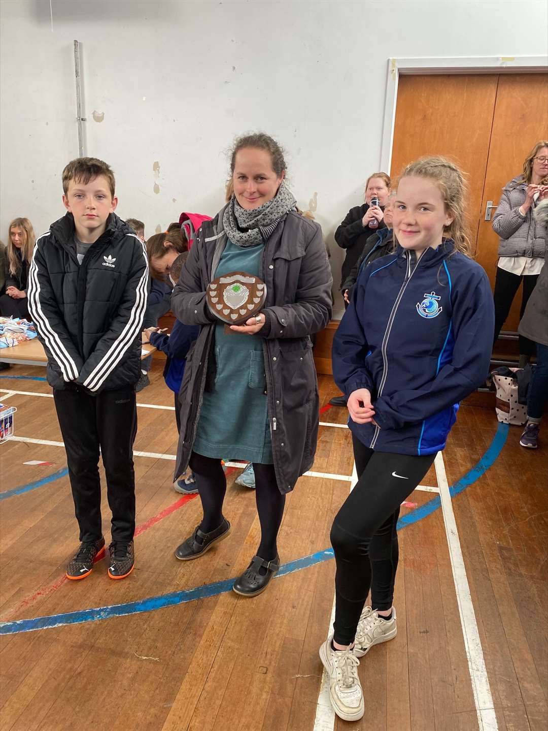 North Coast Campus head teacher Katherine Wood presents Keiran Donner and Zara MacKintosh, flag bearers for winning team the Stags, with the shield.