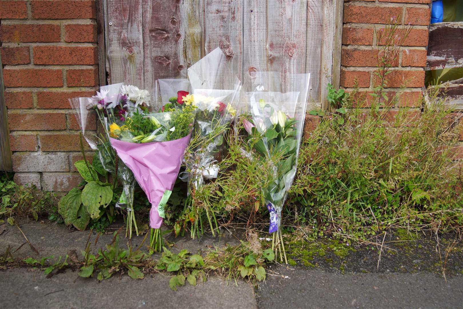 Flowers left outside Donald Patience’s property on Ainsworth Road (Peter Byrne/PA)