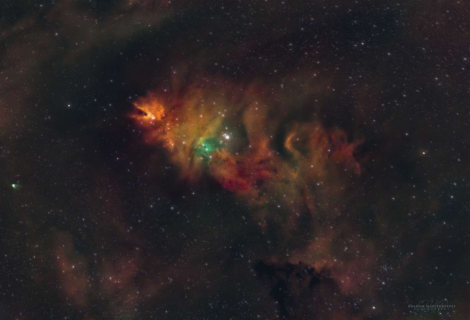 The Cone Nebula and Christmas Tree cluster lie some 2,350 light years from earth in the constellation of Monoceros. It is an emission nebula and star cluster – the colour green shows the oxygenrich gas clouds, red the hydrogen rich areas and the ambers/orange are sulphur rich dust clouds.