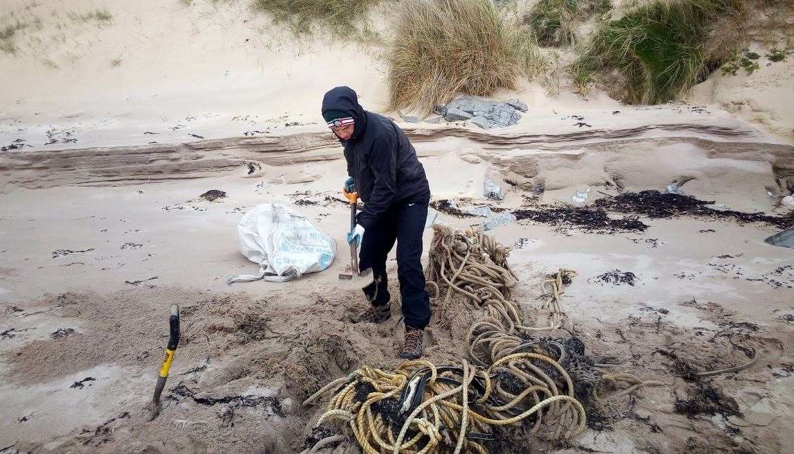 Plastic@Bay coastal ranger Conor Drummond hard at working clearing debris from a beach.