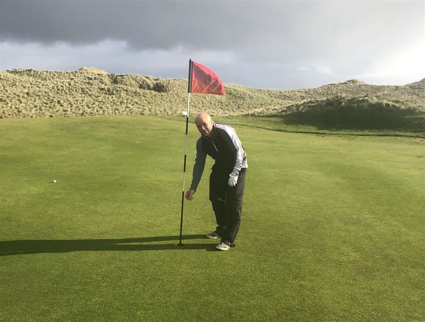 Billy Ferries collects his ball after his hole in one.