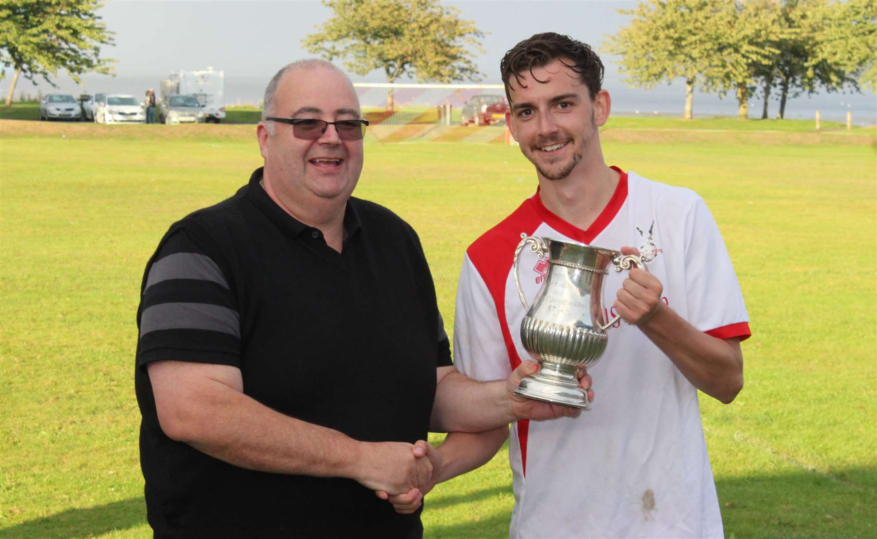 League secretary Hugh Morrison presents the league trophy to Tain Thistle player Darran Goller in 2019, the last time the league was played.