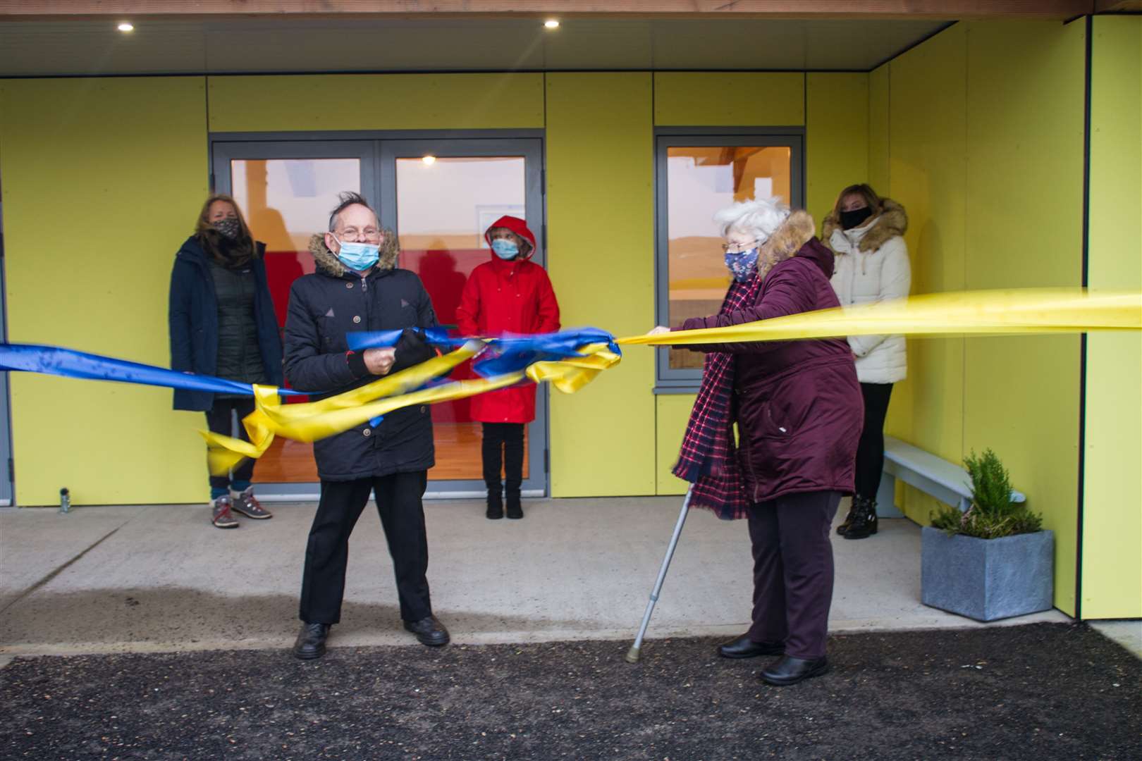 Christopher and Margaret Mackay tug the ribbon in front of the hall. Looking on behind, from left, are committee members Tracy Wilkinson, Marigold Cassidy and Valerie Jappy.