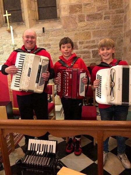 Father Simon Scott with young members of Strathfleet Buttons and Bows, Donald Barclay and Callum McInnes.