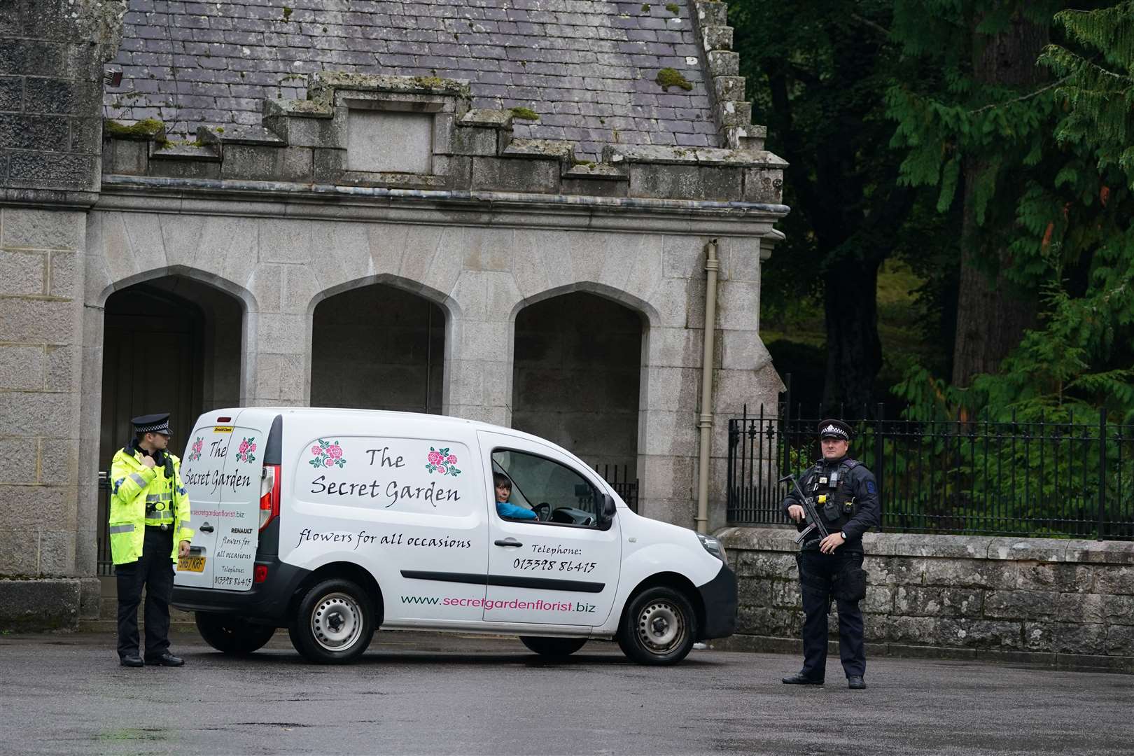 A florist van arrives at the gates, which are guarded by an armed police officer after the Palace announces the Queen is under medical supervision (Andrew Milligan/PA)