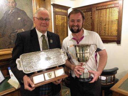 Royal Dornoch Golf Club captain Jim Seatter (left) helps Sinclair Cup winner Alex MacDonald show off the trophies after the prize giving.