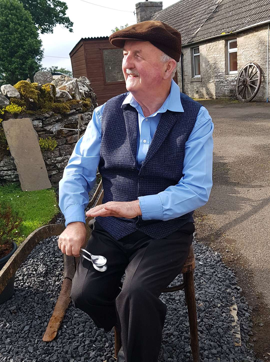 Willie on the spoons outside his cottage at Oldhall, Watten.