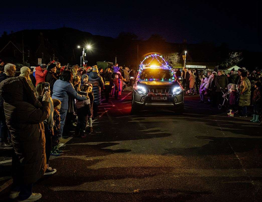 Santa arrived in a car bedecked with lights. Picture: Martin Ross