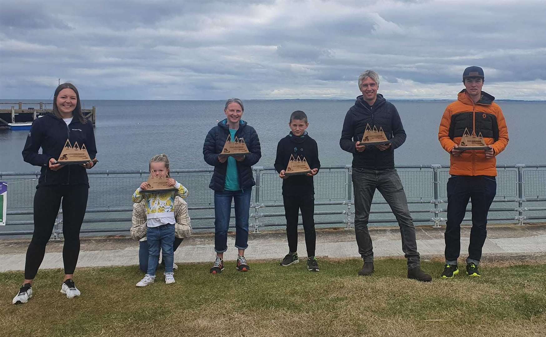 Winners of the inaugural Golspie 3 Peaks Challenge in 2021 show off the handmade trophies they were awarded.