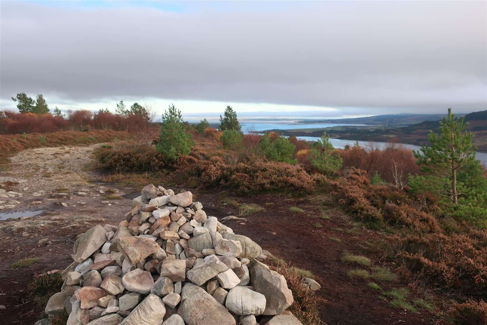 The summit cairn on A’Chraisg and the view out to the Dornoch Firth, taken during an autumn run at Migdale.
