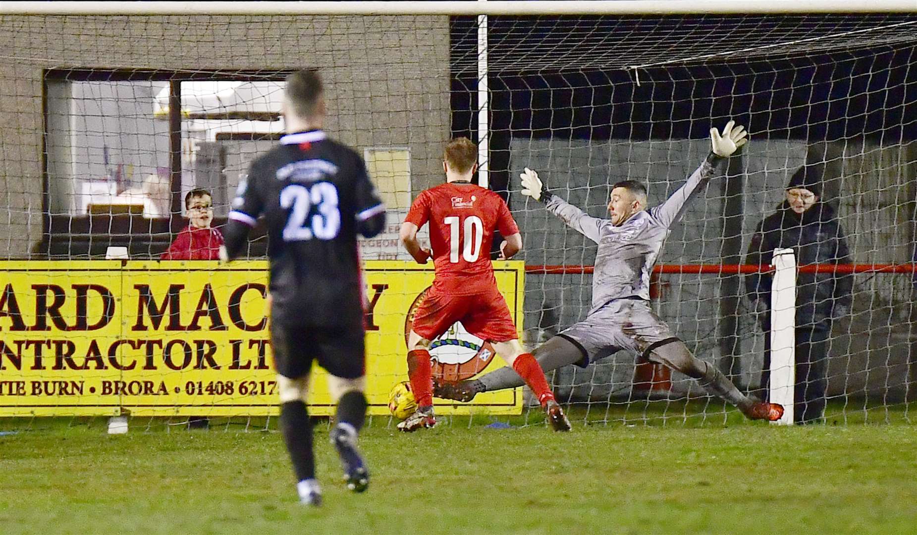 Wick keeper Graeme Williamson is at full stretch as Andy Macrae slots the ball in for Brora's third goal at Dudgeon Park. Picture: Mel Roger